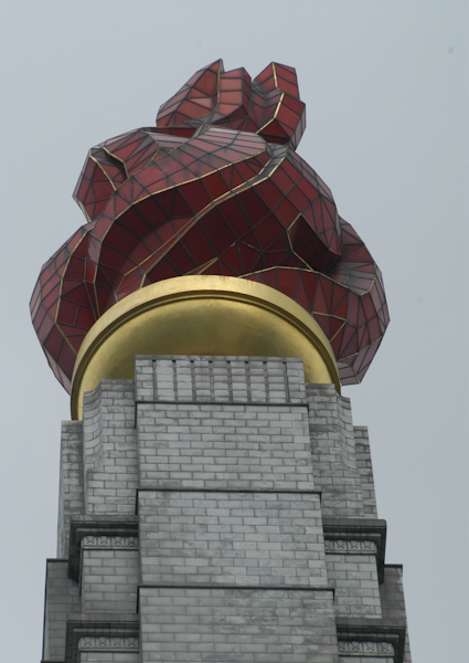На вершине столба — факел высотой 20 метров, который символизирует «великое и немеркнущее торжество идей чучхе»