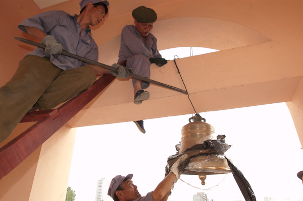 Рабочие подвешивают колокола